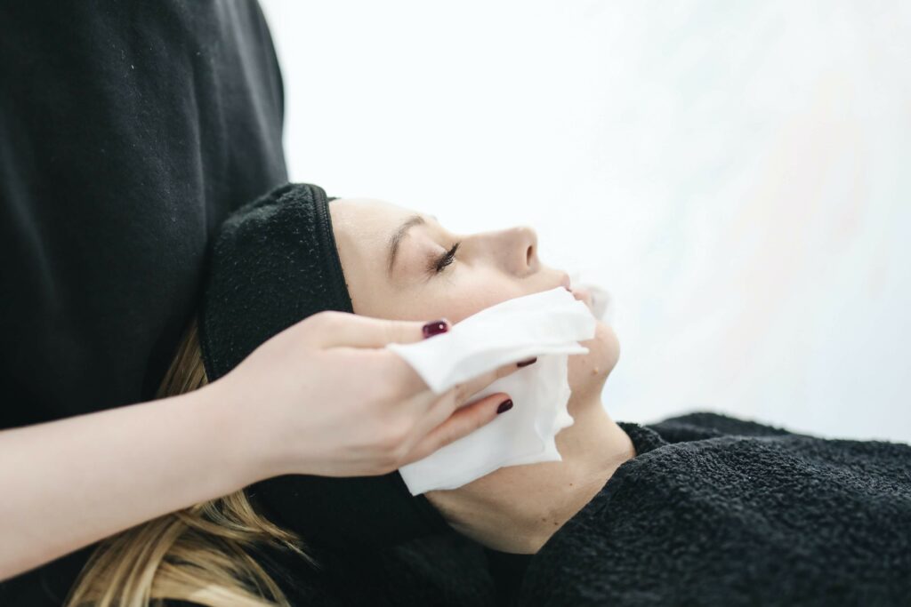 Mujer a la que le están limpiando la cara para iniciar con el tratamiento de regeneración e hidratación