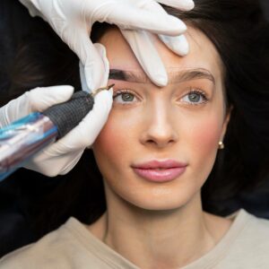 Chica empezando hacerse un tratamiento de tatuado en cejas.